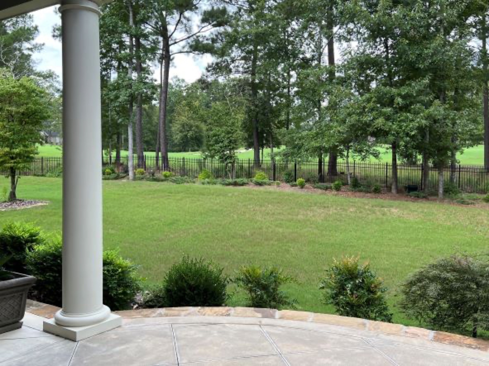 A columned veranda looking over the lawn of a Par 3 home
