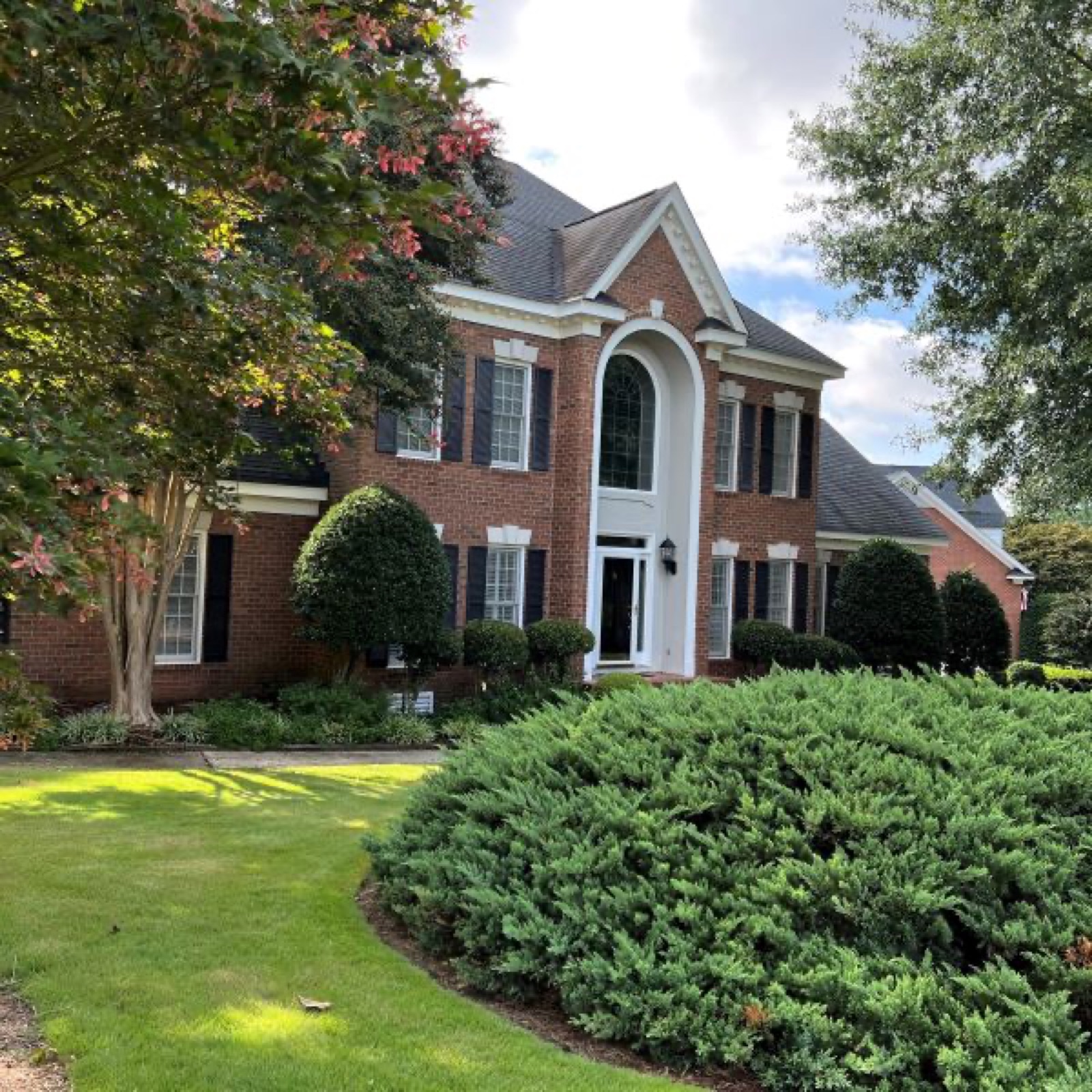 The motor court of a brick Par 3 home